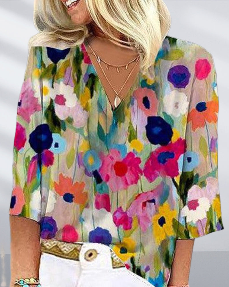 En fargerik fritidsbluse med blomstertrykk med V-hals og trekvart erme