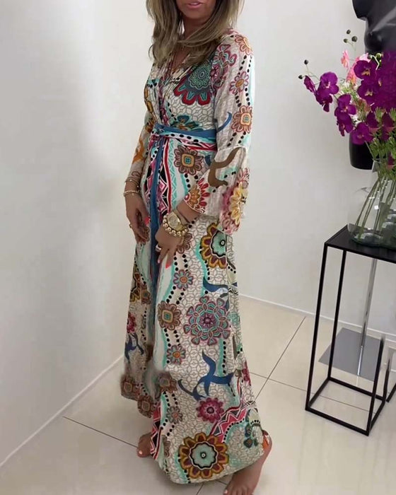 Elegant kjole med fargerikt trykk og klokkeermer