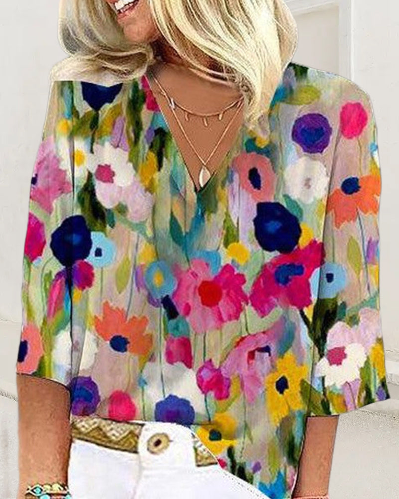 En fargerik fritidsbluse med blomstertrykk med V-hals og trekvart erme