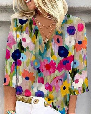 En fargerik fritidsbluse med blomstertrykk med V-hals og trekvart erme