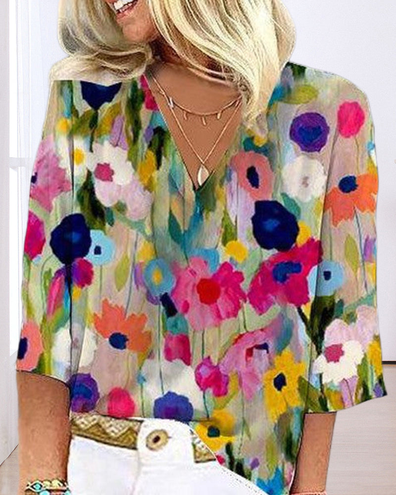 En fargerik fritidsbluse med blomstertrykk med V-hals og trekvart erme
