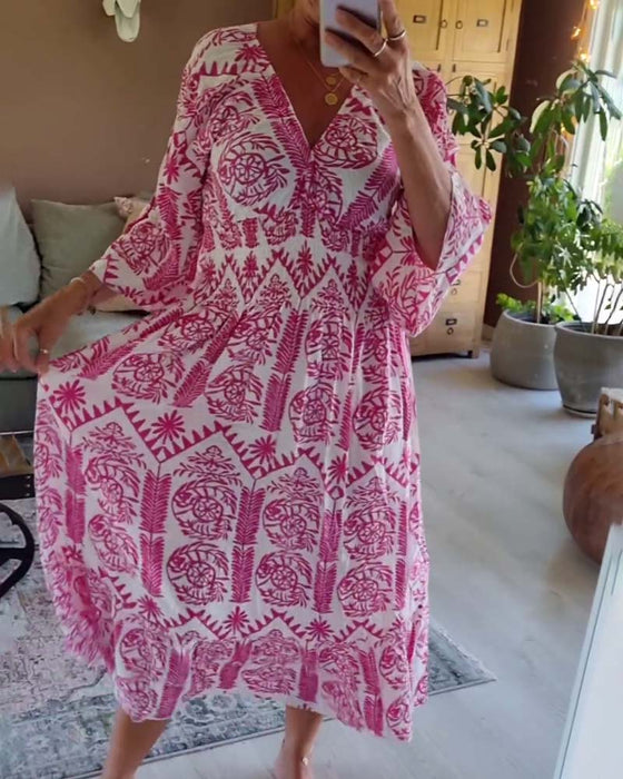 Elegant kjole med trykk med V-hals-fold og klokkeerm