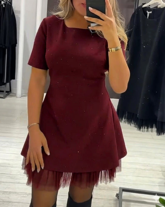 Elegant kjole med skimrende mesh-lappeteppe