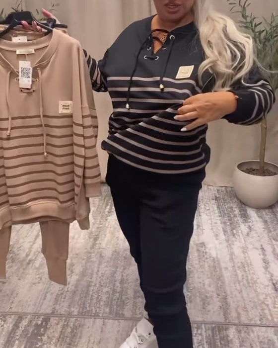 Todelt Sett Med Avslappet Stripet Sportsbukse Ved Ankelen