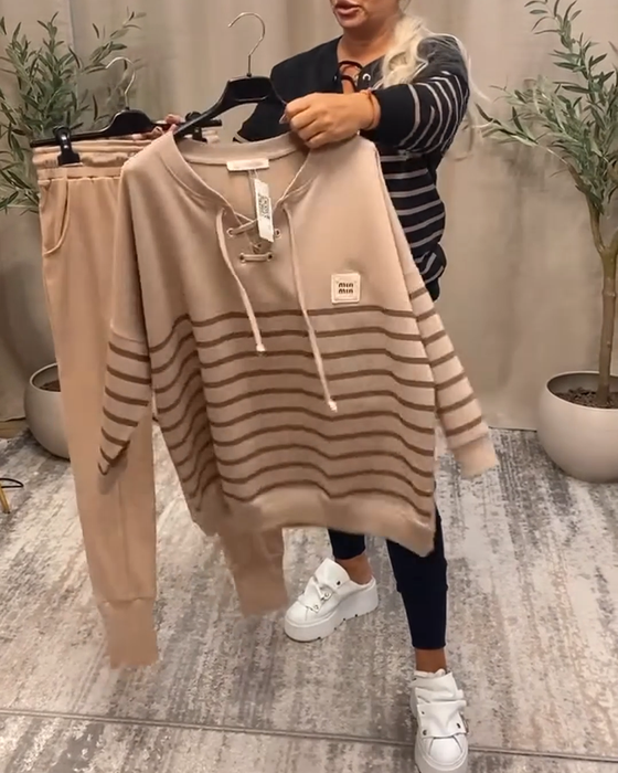 Todelt Sett Med Avslappet Stripet Sportsbukse Ved Ankelen