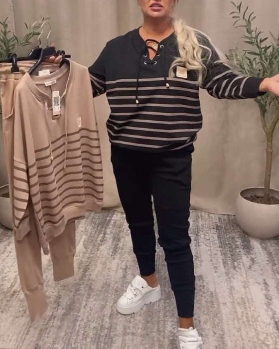 Todelt Sett Med Avslappet Stripet Sportsbukse Ved Ankelen