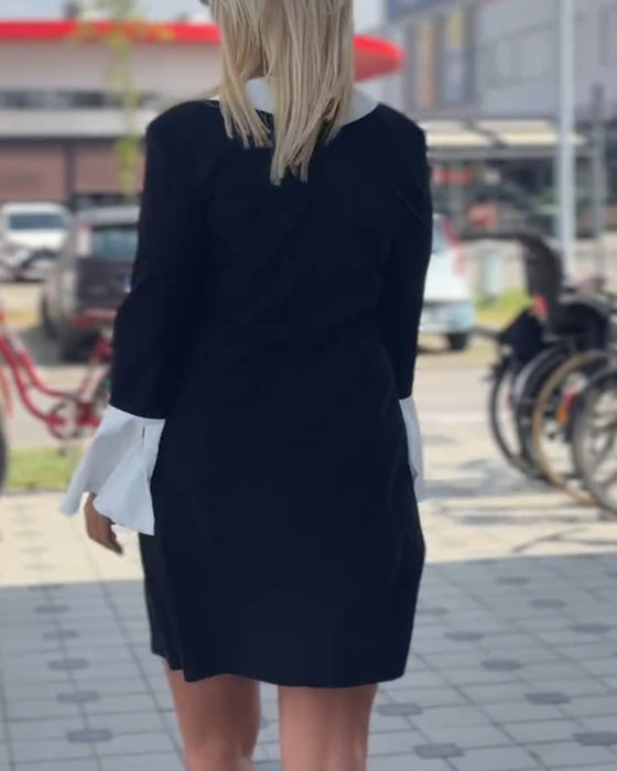 Elegant kjole med klokkeermer i kontrastfarge