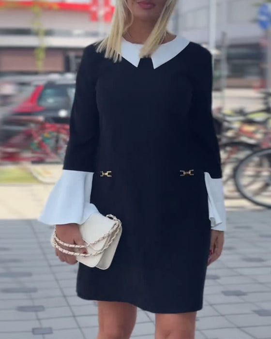 Elegant kjole med klokkeermer i kontrastfarge