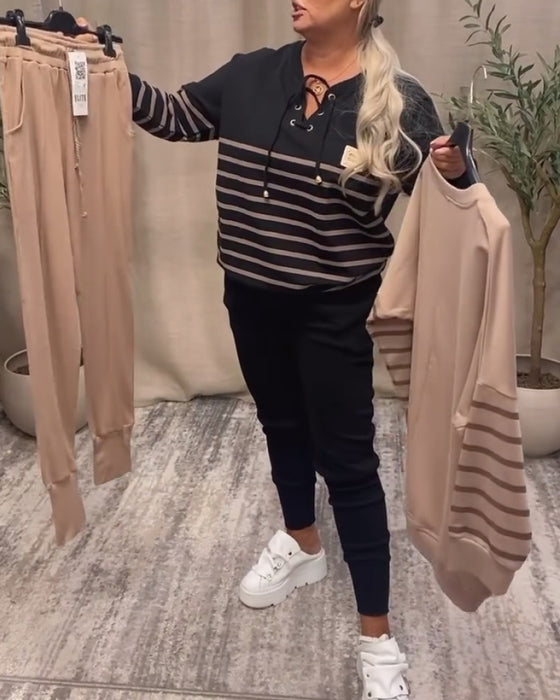 Todelt Sett Med Avslappet Stripet Sportsbukse Ved Ankelen