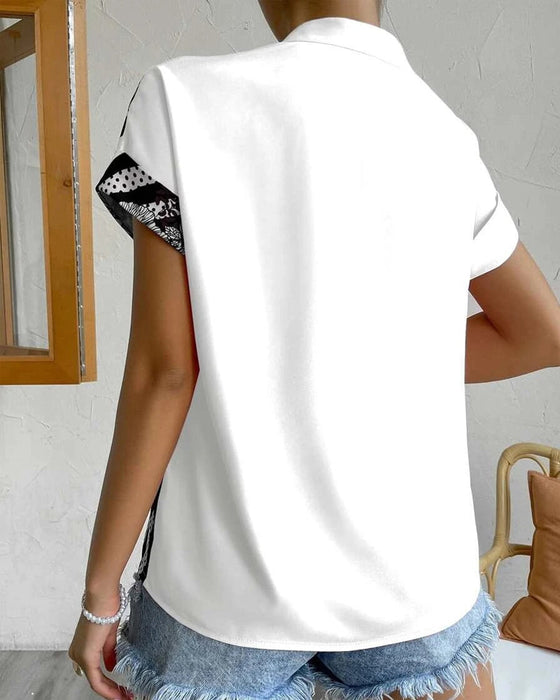 Bluse i panelt blomsterprint med knapp og kort erme