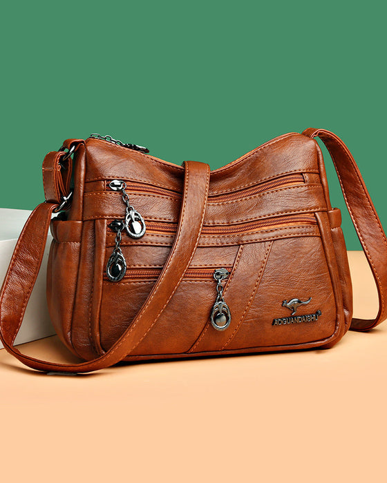 Crossbody-veske i mykt skinn med multilomme