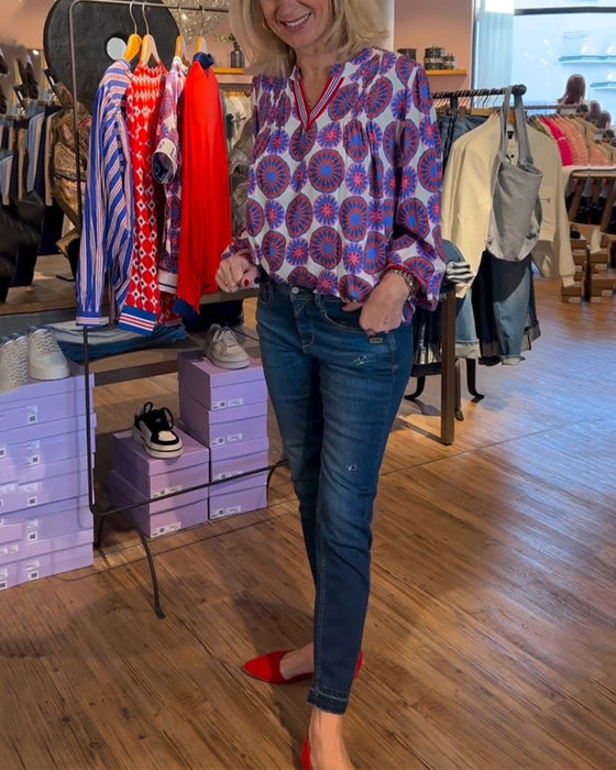 Elegant v-ringad blus med geometriskt tryck