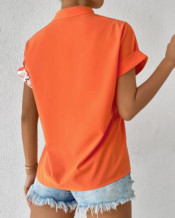 Bluse i panelt blomsterprint med knapp og kort erme